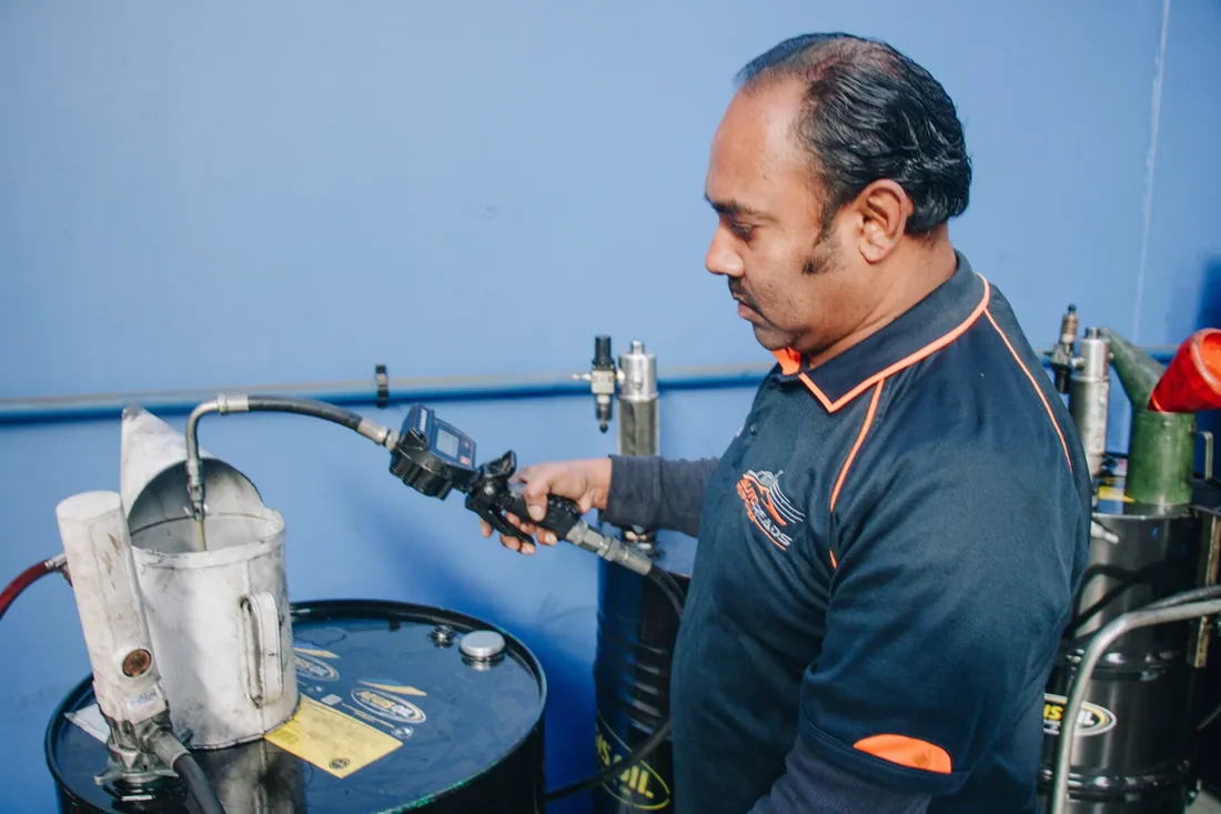 AutoTreads technician performing a precision wheel alignment in the East Tamaki workshop