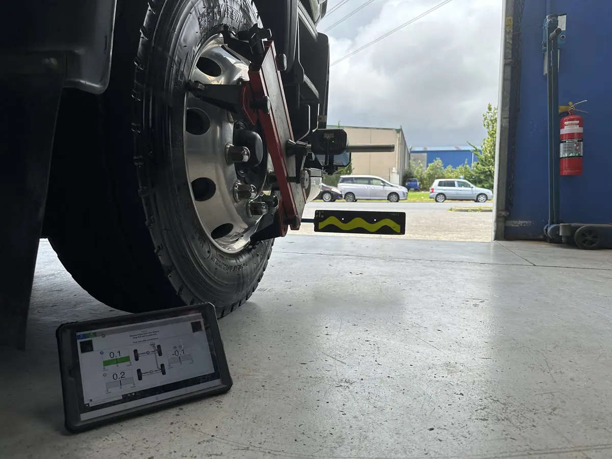AutoTreads technician inspecting and aligning a heavy-vehicle wheel