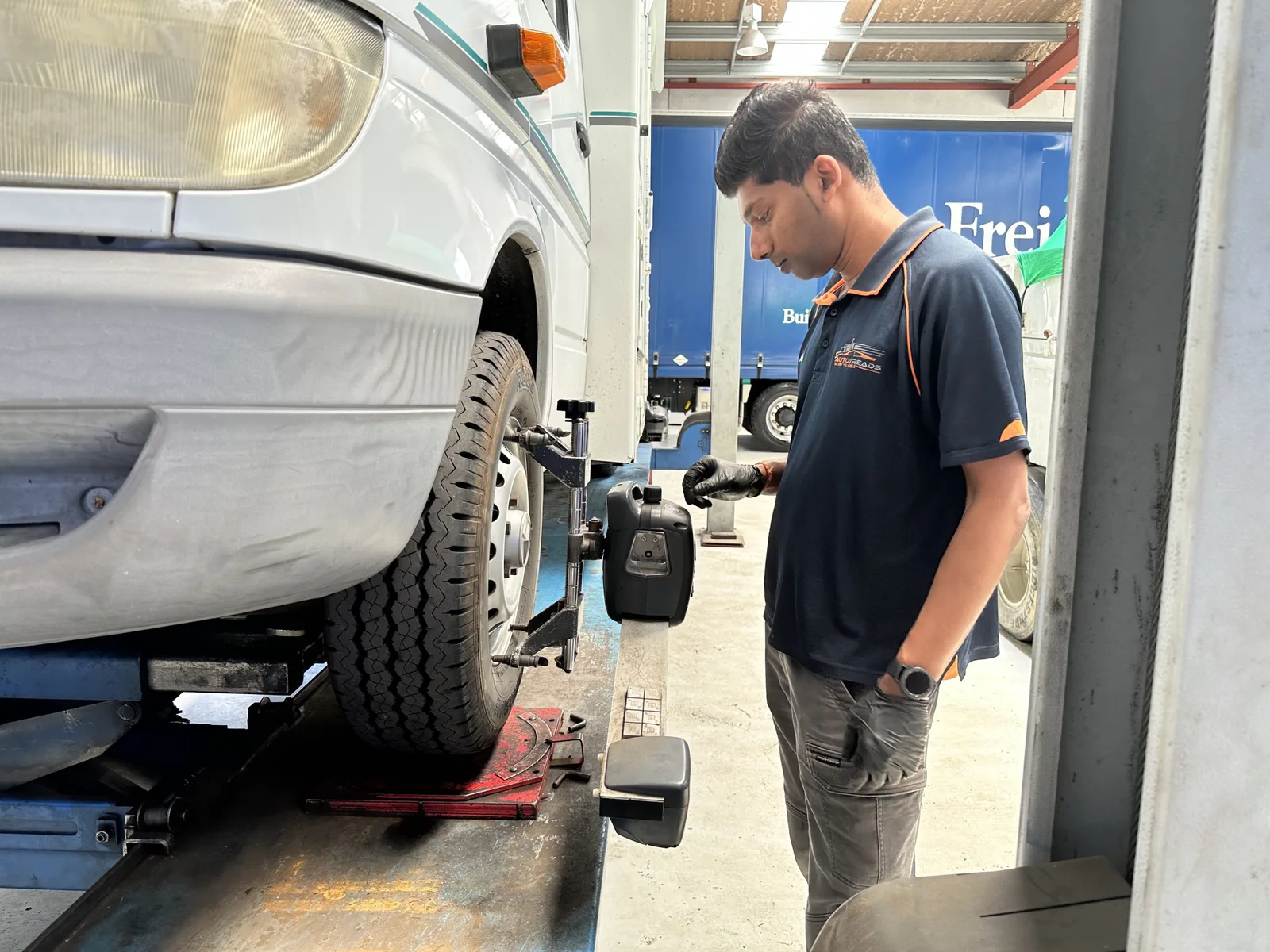 Car on the AutoTreads wheel alignment lift with a technician at work