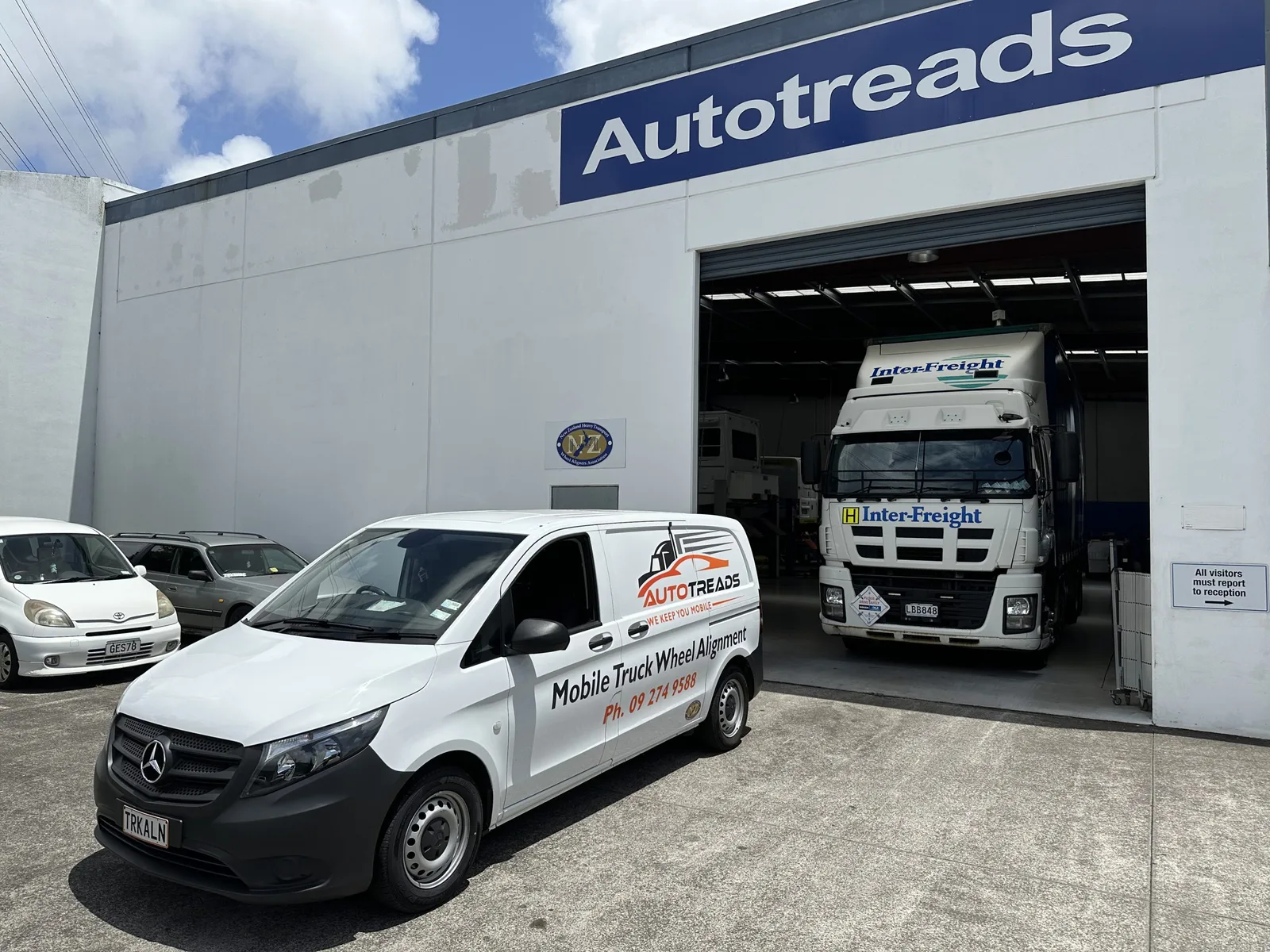 AutoTreads workshop bay with the branded service van and a truck beneath the Autotreads sign